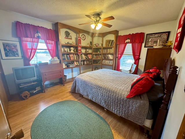 bedroom featuring a textured ceiling, ceiling fan, and wood finished floors