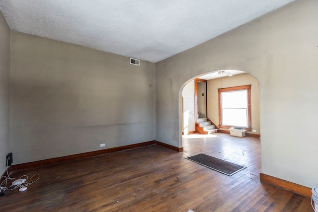 unfurnished room featuring dark hardwood / wood-style flooring and a textured ceiling