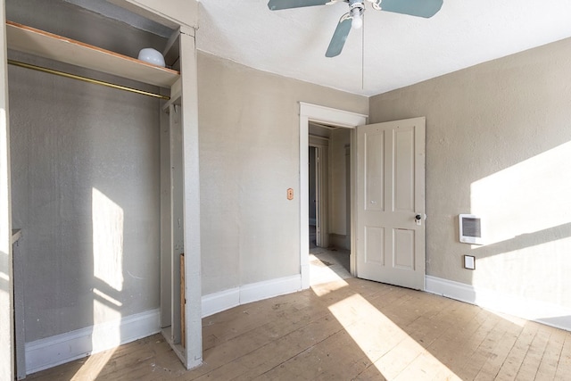 unfurnished bedroom with ceiling fan, a closet, and light hardwood / wood-style floors