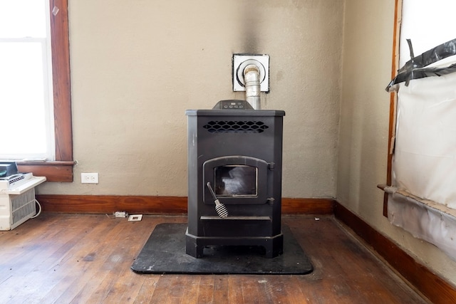 interior details featuring a wood stove and hardwood / wood-style flooring