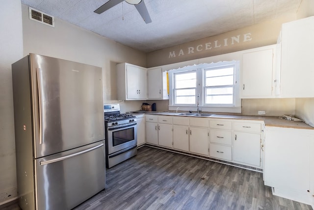 kitchen featuring ceiling fan, appliances with stainless steel finishes, dark hardwood / wood-style flooring, white cabinets, and sink