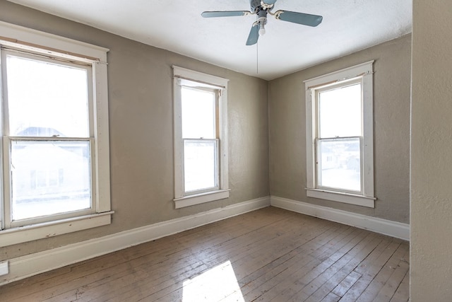 unfurnished room featuring ceiling fan, a healthy amount of sunlight, and hardwood / wood-style flooring