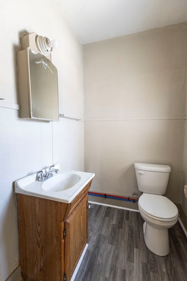 bathroom with toilet, hardwood / wood-style flooring, and vanity