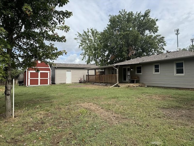 rear view of house featuring a yard and a storage unit