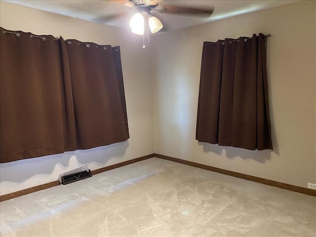 carpeted spare room with ceiling fan