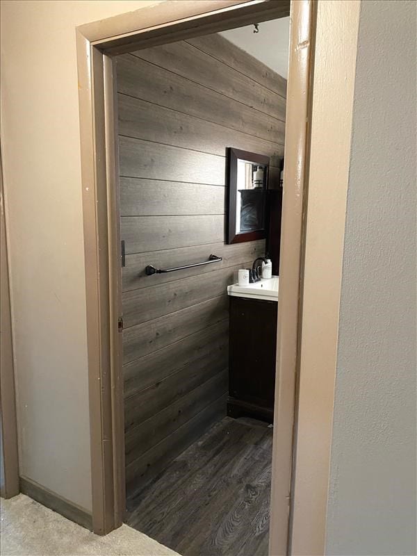 bathroom featuring wooden walls and vanity