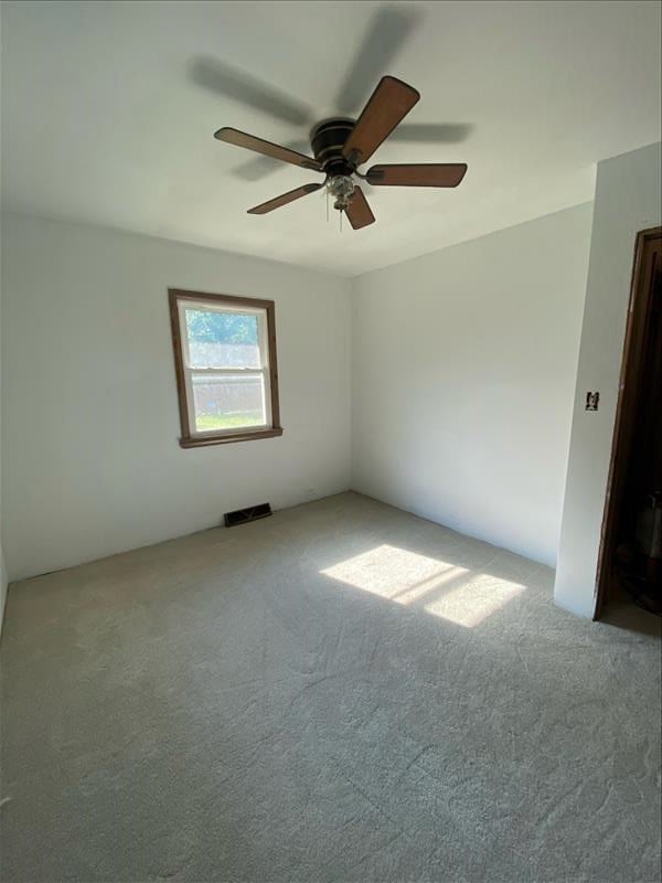 carpeted spare room featuring ceiling fan