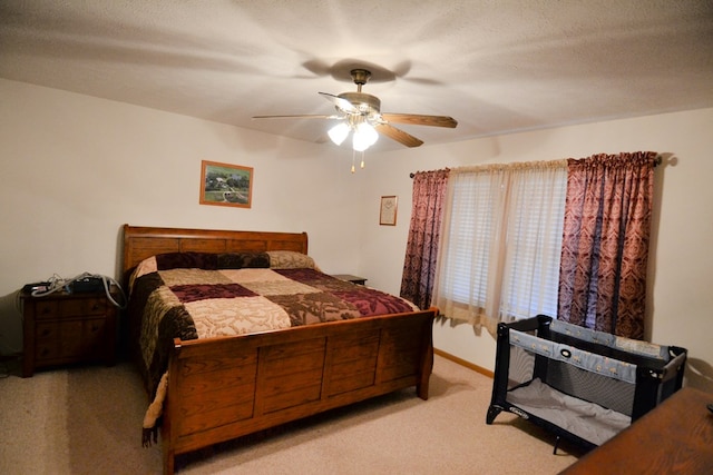 carpeted bedroom with a textured ceiling and ceiling fan