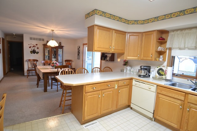 kitchen with dishwasher, sink, a kitchen breakfast bar, kitchen peninsula, and decorative light fixtures