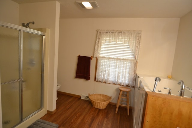 bathroom featuring hardwood / wood-style floors, toilet, and a shower with shower door