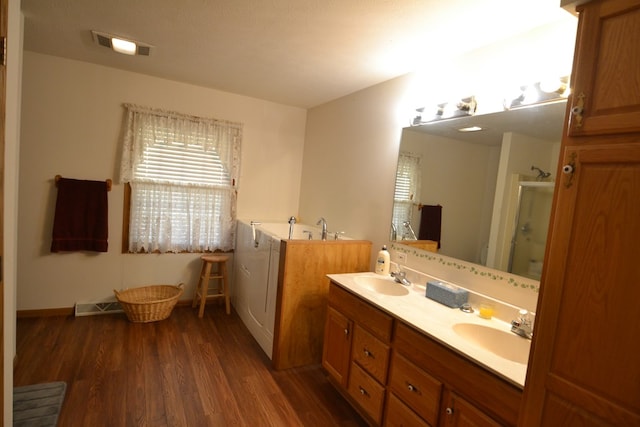 bathroom with hardwood / wood-style floors, vanity, and a shower with door