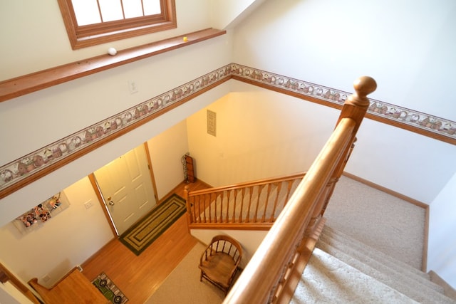 stairs featuring carpet and a high ceiling