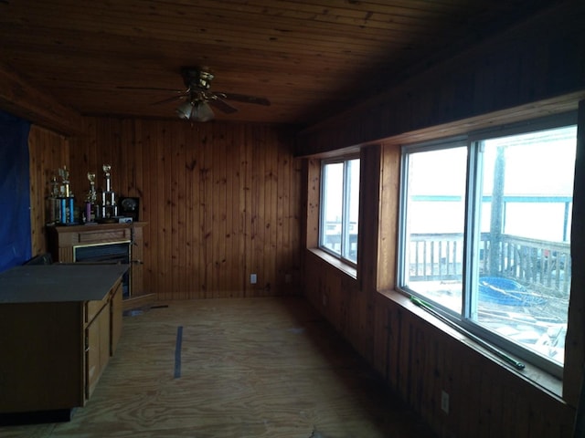 sunroom / solarium with ceiling fan, wood ceiling, and a fireplace