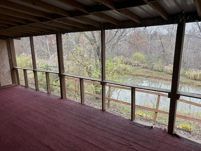 wooden terrace featuring a view of trees and a water view