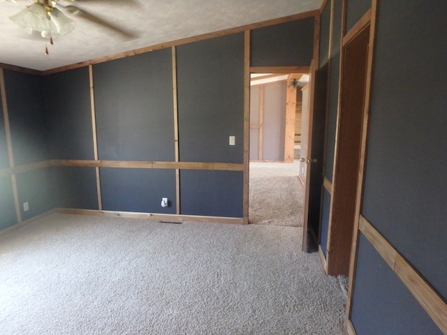 unfurnished room featuring ceiling fan and carpet flooring