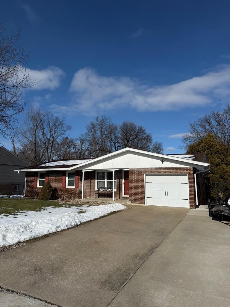 ranch-style house featuring a garage and covered porch