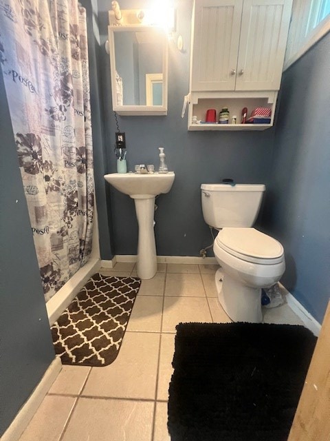 bathroom with toilet, tile patterned floors, and curtained shower