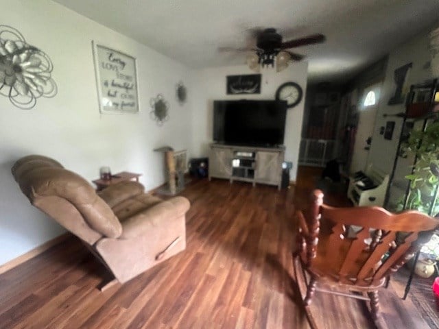 living room with ceiling fan and dark hardwood / wood-style flooring