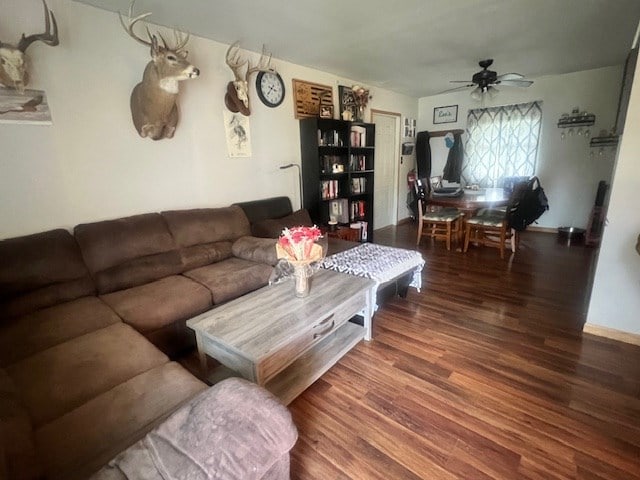 living room with ceiling fan and dark wood-type flooring