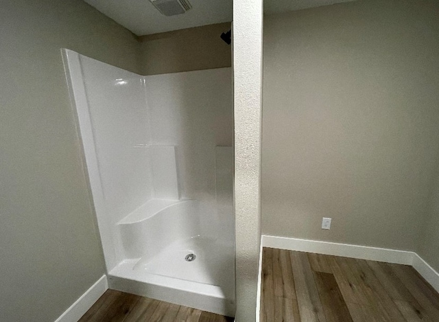 bathroom with walk in shower and hardwood / wood-style flooring