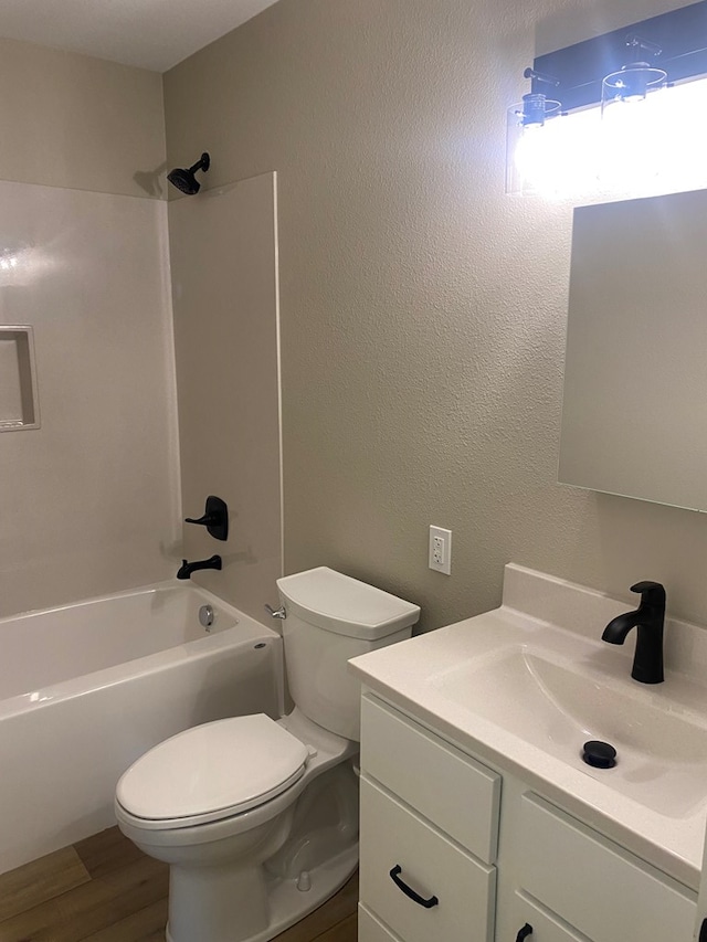 full bathroom with hardwood / wood-style flooring, vanity,  shower combination, and toilet