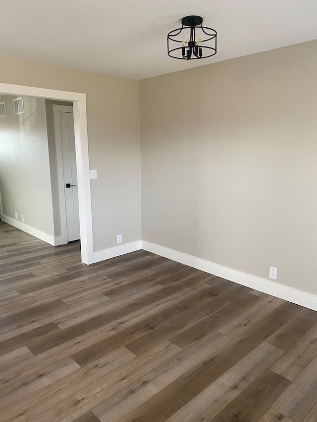 unfurnished dining area featuring dark hardwood / wood-style floors and an inviting chandelier