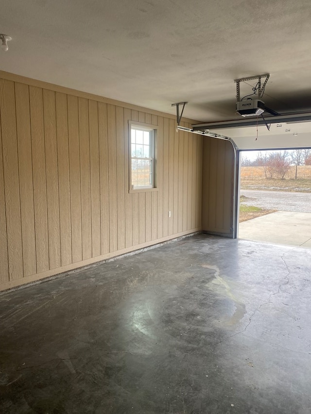 garage with a garage door opener and wooden walls