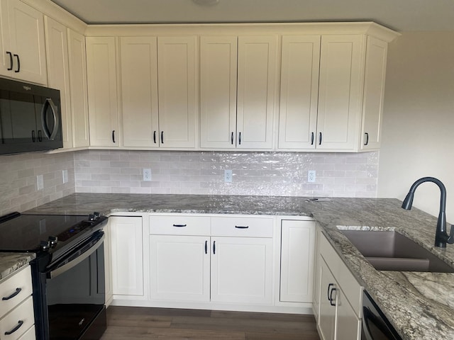 kitchen featuring sink, white cabinetry, light stone counters, tasteful backsplash, and black appliances