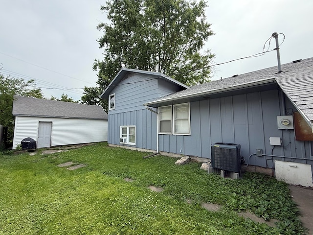 1205 Randolph St, Kirksville, MO 63501 - view of home's exterior with board and batten siding, a yard, and a shingled roof