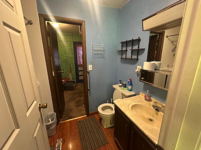 full bathroom with visible vents, toilet, vanity, and wood finished floors