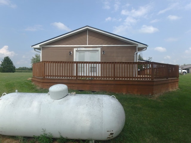 rear view of property featuring a yard and a wooden deck