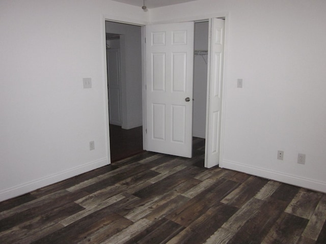 unfurnished bedroom featuring a closet and dark hardwood / wood-style floors