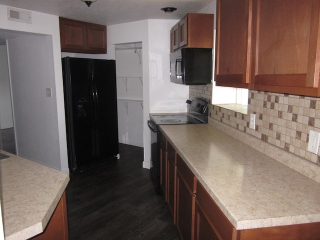 kitchen with backsplash, dark wood-type flooring, and black appliances