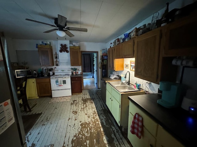 104 Conkle, Brashear, MO 63533 - kitchen with appliances with stainless steel finishes, a sink, a ceiling fan, light wood-style flooring, and dark countertops