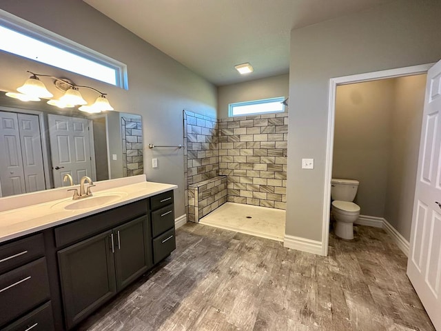 bathroom featuring a tile shower, plenty of natural light, vanity, and hardwood / wood-style flooring