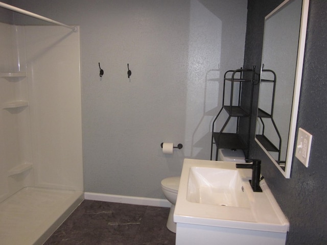 bathroom featuring vanity, toilet, and walk in shower