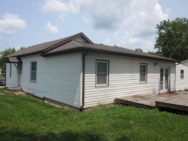 view of side of property featuring a deck and a lawn