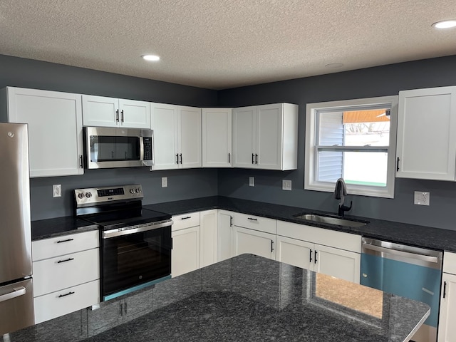 1216 N Franklin St, Kirksville, MO 63501 - kitchen featuring a textured ceiling, a sink, white cabinetry, and appliances with stainless steel finishes