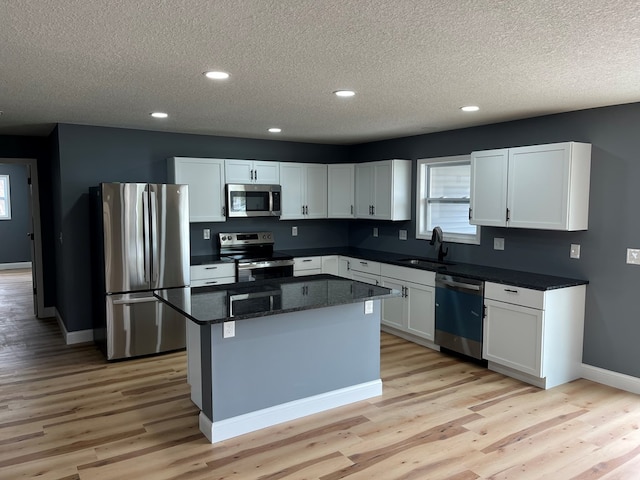 1216 N Franklin St, Kirksville, MO 63501 - kitchen with a kitchen island, a textured ceiling, a sink, and appliances with stainless steel finishes