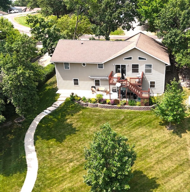 rear view of house featuring a yard, a patio, and a deck