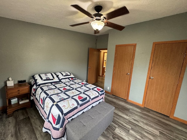 bedroom with ceiling fan, hardwood / wood-style floors, and a textured ceiling