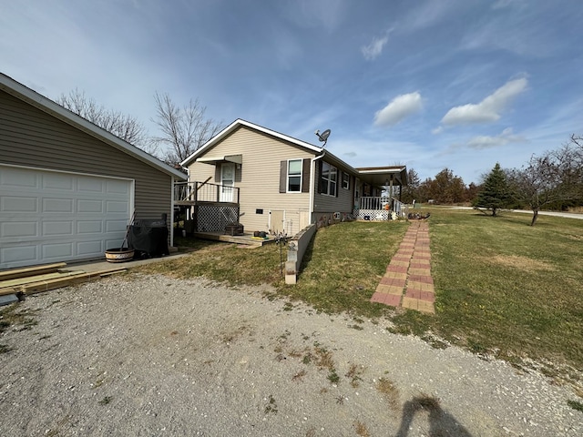 view of home's exterior with covered porch, a garage, and a lawn