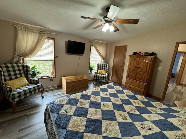 sitting room with vaulted ceiling, ceiling fan, dark wood-type flooring, and a textured ceiling