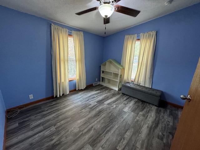 unfurnished bedroom featuring ceiling fan, dark hardwood / wood-style flooring, and a textured ceiling