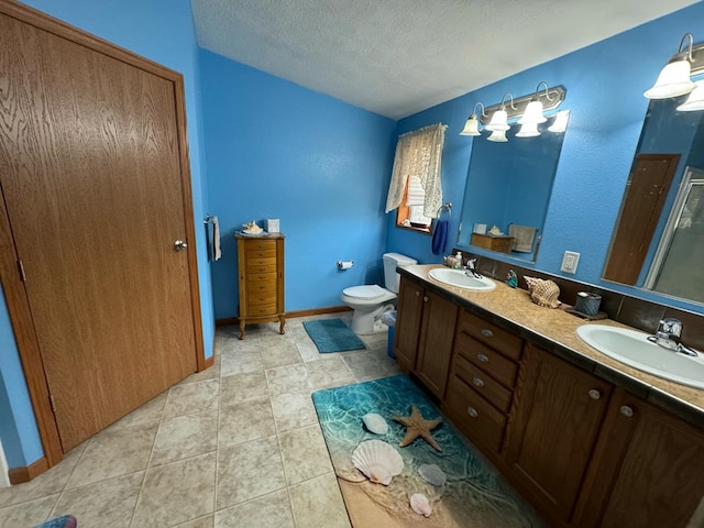 bathroom featuring tile patterned floors, vanity, toilet, and a textured ceiling