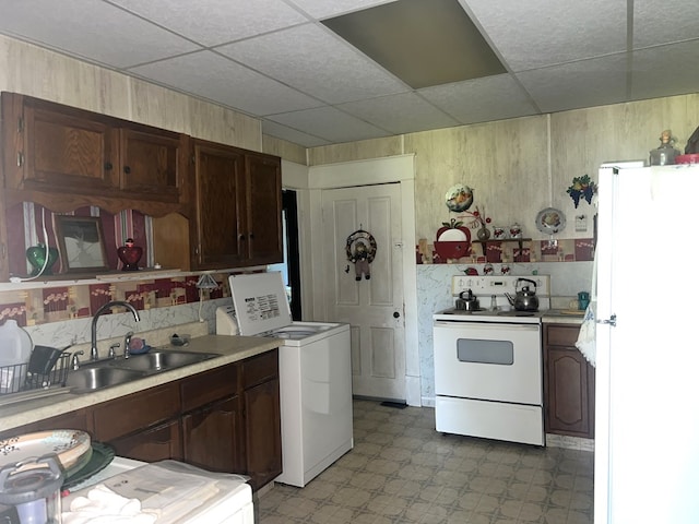 110 Van Buren St, Browning, MO 64630 - kitchen featuring white appliances, light floors, washer / clothes dryer, a drop ceiling, and light countertops