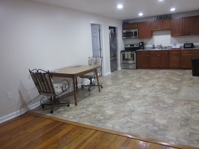 kitchen featuring light wood-type flooring, sink, and appliances with stainless steel finishes