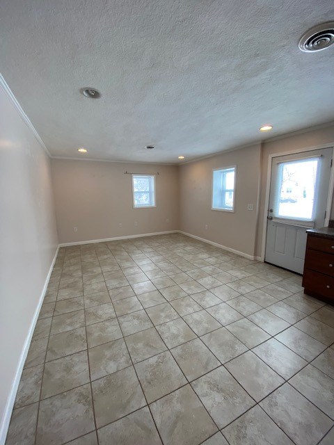 interior space with a textured ceiling and ornamental molding