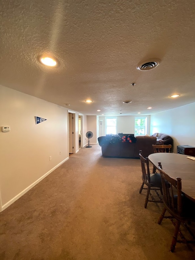 dining space featuring carpet flooring and a textured ceiling