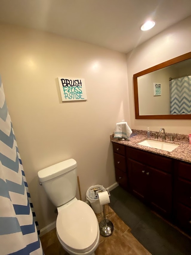 bathroom with tile patterned flooring, vanity, and toilet